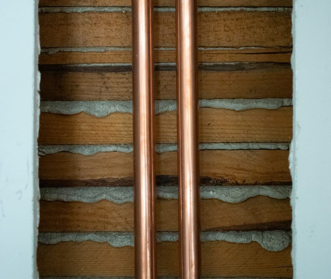 New copper water pipes installed inside an opened plaster wall