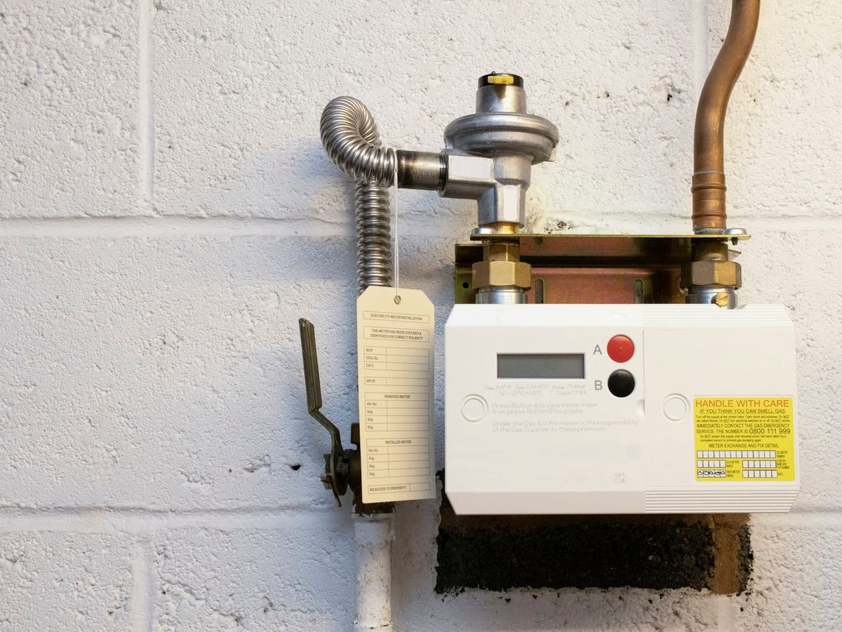 Installed gas meter with shutoff valve and supply piping on a wall